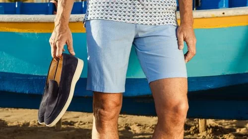 suède loafers met korte broek op het strand